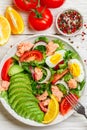 Delicious fish salad salmon or tuna with lettuce, tomatoes, red onion, eggs and avocado with dressing of olive oil , mustard and Royalty Free Stock Photo