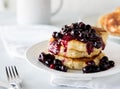 Delicious fluffy pancake stack with warm blueberry sauce ready for eating. Royalty Free Stock Photo