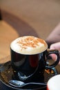 Delicious foamy cappuccino on a black cup