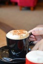 Delicious foamy cappuccino on a black cup