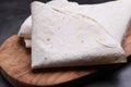 Delicious folded Armenian lavash on dark table, closeup