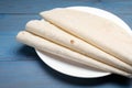 Delicious folded Armenian lavash on light blue wooden table, closeup