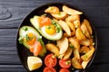 Delicious food: Baked avocado stuffed with eggs and salmon, fresh tomatoes and potato close-up. Horizontal top view Royalty Free Stock Photo