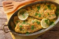 Delicious food: trout fish with garlic lemon butter sauce, parsley close-up in a copper frying pan. horizontal top view