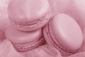 Delicious french dessert. Three gentle soft pastel pink purple cakes macaron or macaroon on airy fabric