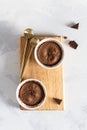 Delicious french fondant with hot chocolate in ramekins on wooden board. Lava cake recipe, menu. Top view