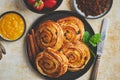 Delicious, fresh baked cinnamon buns served on black ceramic plate. With various sides Royalty Free Stock Photo