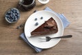 Delicious fresh chocolate cake with blueberries on wooden table, flat lay Royalty Free Stock Photo