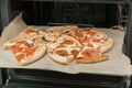 Delicious fresh crispy pizza slices with mushrooms, cheese, bacon and Pepperoni sausages closeup on sheet of paper after heating Royalty Free Stock Photo