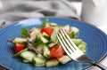 Delicious fresh cucumber tomato salad and fork on table Royalty Free Stock Photo