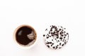 Delicious fresh donut black and white color with white icing and chocolate chips with paper glass of coffe closeup on a