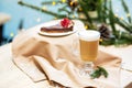 Delicious fresh festive morning cappuccino coffee in a glass cup and cupcake dessert on the wooden table, fireflies and spruce
