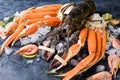 Delicious fresh fish and seafood on dark vintage background. Fish, clams and shrimps with aromatic herbs, spices and vegetables Royalty Free Stock Photo