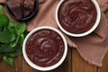 Delicious fresh fondant, chocolate and mint on wooden table, flat lay