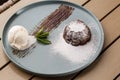 Delicious fresh fondant with hot chocolate and ice cream and mint served on plate. Lava cake recipe. Wooden background. Royalty Free Stock Photo