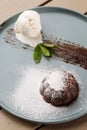 Delicious fresh fondant with hot chocolate and ice cream and mint served on plate. Lava cake recipe. Wooden background. Royalty Free Stock Photo