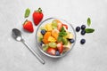 Delicious fresh fruit salad in bowl on light table, flat lay Royalty Free Stock Photo