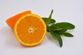 Healthy ripe delicious fruits for human health. Juicy fruits of orange orange with bright green mint. Two halves of an orange with Royalty Free Stock Photo