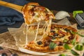 Delicious fresh and homemade fast food. A piece of pizza with bacon, basil, olives, pickles and mozzarella cheese close-up on Royalty Free Stock Photo