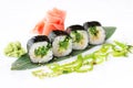 Delicious fresh mini-rolls with algae of Chukka on a banana leaf. Sushi rolls on a white background with ginger and