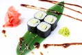 Delicious fresh mini-rolls with cucumber on a banana leaf. Sushi rolls on a white background with ginger and wasabi. The Japanese