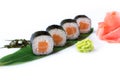 Delicious fresh mini-rolls with salmon on a banana leaf. Sushi rolls on a white background with ginger and wasabi. Royalty Free Stock Photo