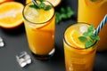 Delicious fresh orange juice with ice, mint and fresh fruits on black table background Royalty Free Stock Photo