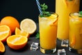 Delicious fresh orange juice with ice, mint and fresh fruits on black table background Royalty Free Stock Photo