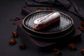 Delicious fresh profiterole or eclair with chocolate on a black ceramic plate Royalty Free Stock Photo