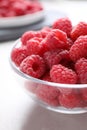 Delicious fresh ripe raspberries in glass bowl on table, closeup Royalty Free Stock Photo