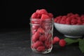 Delicious fresh ripe raspberries in glass jar on table Royalty Free Stock Photo
