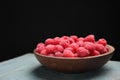 Delicious fresh ripe raspberries in plate on wooden table Royalty Free Stock Photo