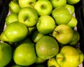 Delicious fresh stacked green apples are on a shelf in the supermarket to be sold
