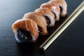 Delicious fresh sushi rolls with salmon and cream cheese on black plate. Traditional japanese food, healthy food concept Royalty Free Stock Photo