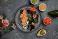 Delicious fresh sushi rolls with salmon and philadelphia cheese on gray plate on dark stone background. Traditional japanese Royalty Free Stock Photo