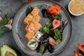 Delicious fresh sushi rolls with salmon and philadelphia cheese on gray plate on dark stone background. Traditional japanese Royalty Free Stock Photo