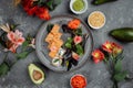 Delicious fresh sushi rolls with salmon and philadelphia cheese on gray plate on dark stone background. Traditional japanese Royalty Free Stock Photo