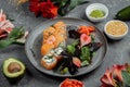 Delicious fresh sushi rolls with salmon and philadelphia cheese on gray plate on dark stone background. Traditional japanese Royalty Free Stock Photo