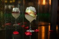 Close up drink shot of a delicious fresh yellow red cocktail with ice, a cucumber slice in a transparent wine glass standing on a Royalty Free Stock Photo