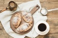 Freshly baked chocolate croissants and cup of black coffee on wooden cutting board. Top view. Breakfast concept. Royalty Free Stock Photo