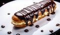 Delicious Freshly Baked Eclair with Smooth Shiny Chocolate Glaze Drizzled Over the Top Isolated on a White Background