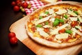 Delicious freshly baked pizza on a wooden paddle topped with tomatoes, parmesan, basil Royalty Free Stock Photo