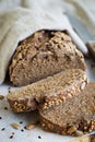 Delicious freshly baked rye bread, brown bread. Whole grain sliced organic bread consisting of seeds on a wooden cutting board. Royalty Free Stock Photo