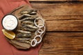Delicious fried anchovies with onion rings, sauce and slice of lemon served on wooden table, top view. Space for text Royalty Free Stock Photo