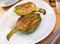 Delicious fried artichoke halves with coarse salt on a white plate Royalty Free Stock Photo