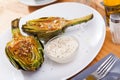 Delicious fried artichoke halves with coarse salt on a white plate Royalty Free Stock Photo