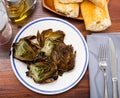 Delicious fried artichoke halves on a white plate Royalty Free Stock Photo