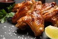 Delicious fried chicken wings and lime on black table, closeup Royalty Free Stock Photo