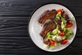 Delicious fried lamb chops served with fresh vegetable salad close-up on a plate. Horizontal top view Royalty Free Stock Photo