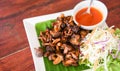 Delicious fried mushrooms in plate on wooden table, top view - cooked shiitake mushrooms fried with tomato sauce and vegetables